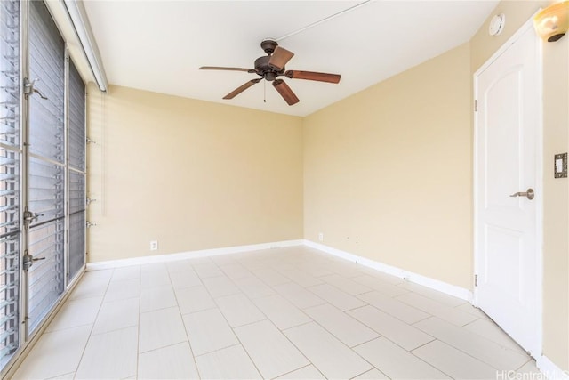 spare room with ceiling fan and baseboards