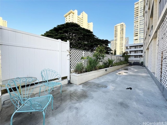 view of patio with a view of city and fence