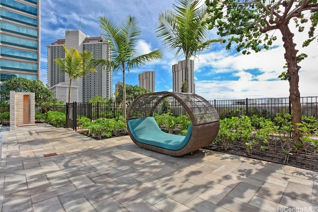 view of patio featuring a view of city and fence