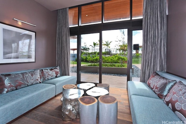 living area with a wall of windows and wood finished floors