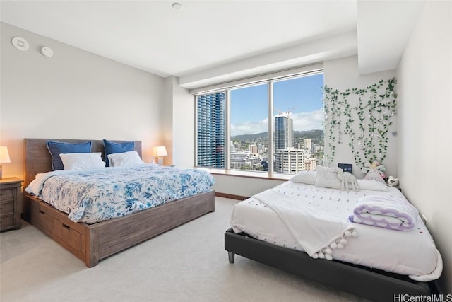 bedroom with light carpet and a city view