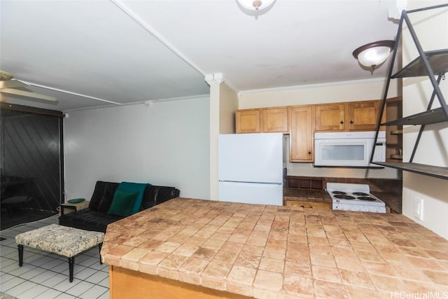 kitchen featuring tile countertops, white appliances, and crown molding