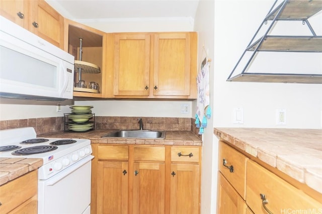 kitchen featuring crown molding, tile counters, glass insert cabinets, a sink, and white appliances