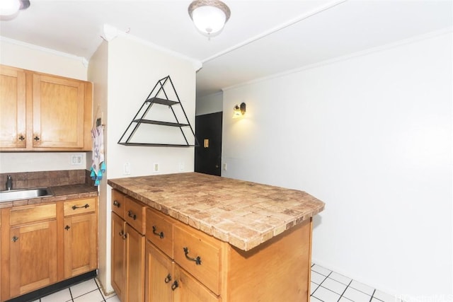 kitchen featuring crown molding, a sink, a peninsula, and light tile patterned floors