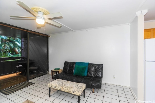 sitting room featuring a ceiling fan, tile patterned flooring, crown molding, and baseboards