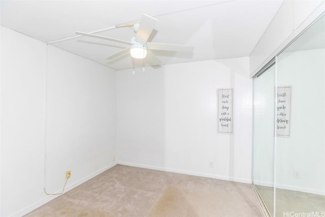 empty room with light carpet, baseboards, and a ceiling fan