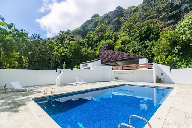 pool featuring fence and a patio