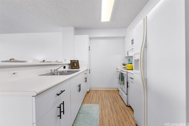 kitchen with light countertops, light wood-style floors, white appliances, white cabinetry, and a sink