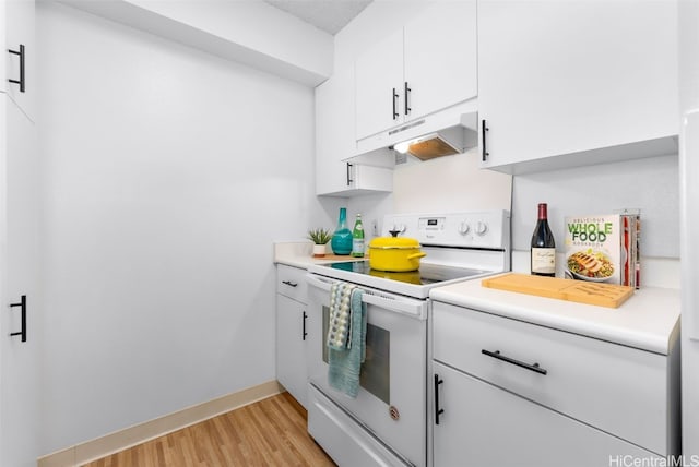 kitchen featuring light wood-type flooring, under cabinet range hood, white electric stove, white cabinets, and light countertops