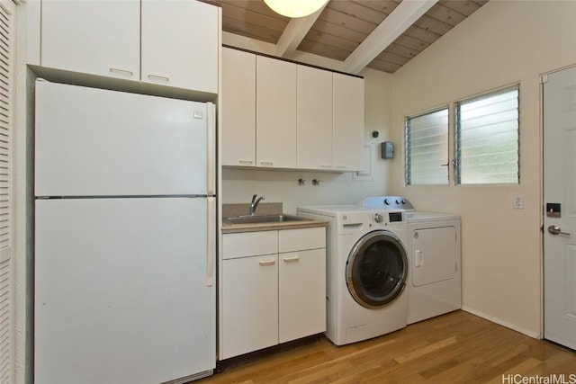 washroom featuring washer and clothes dryer, wood ceiling, light wood-style floors, cabinet space, and a sink