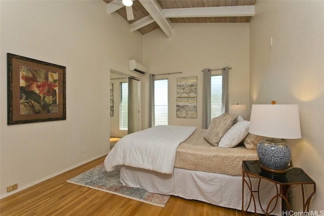 bedroom with wood finished floors, baseboards, high vaulted ceiling, beam ceiling, and an AC wall unit