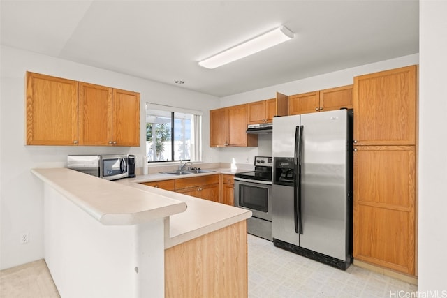 kitchen with light floors, appliances with stainless steel finishes, a peninsula, and light countertops