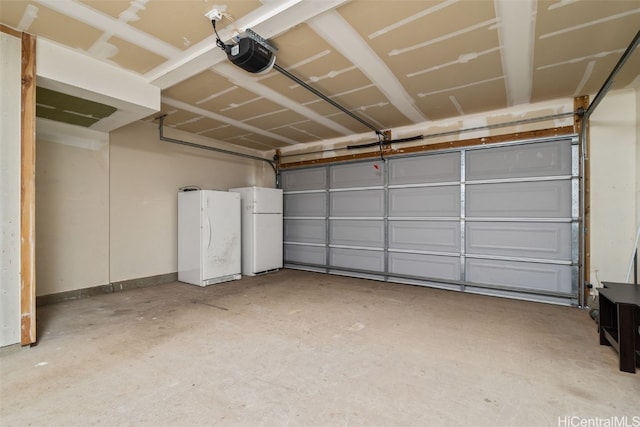 garage with a garage door opener, baseboards, and freestanding refrigerator