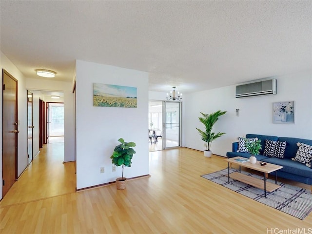 living area featuring a wall mounted AC, plenty of natural light, and light wood-style floors