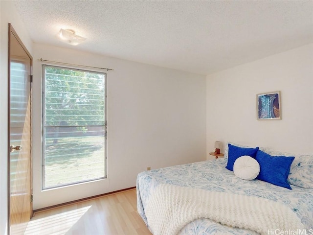 bedroom with light wood finished floors and a textured ceiling