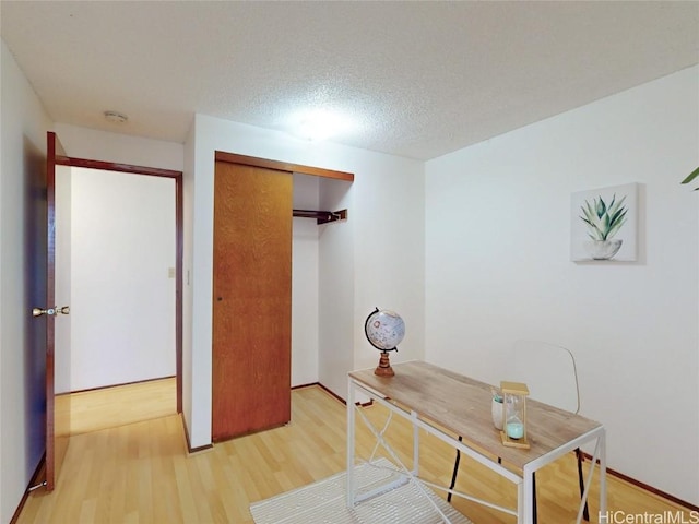 home office featuring a textured ceiling and wood finished floors