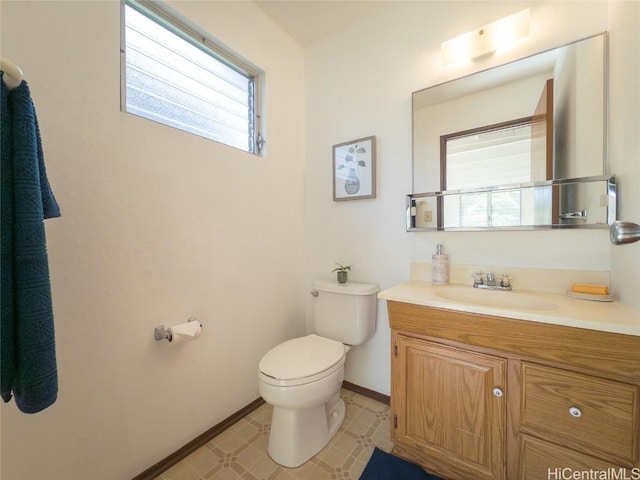 bathroom with toilet, baseboards, and vanity