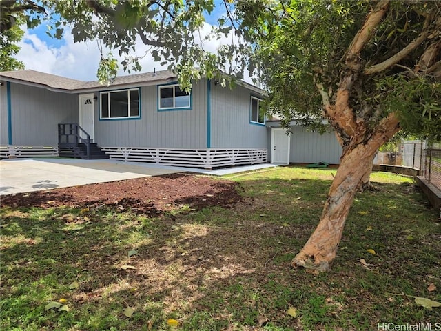 view of side of home featuring entry steps, fence, a lawn, and a patio