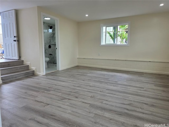 empty room with baseboards, wood finished floors, and recessed lighting