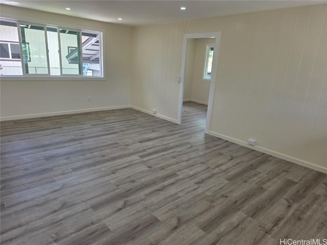 spare room featuring baseboards, wood finished floors, and recessed lighting