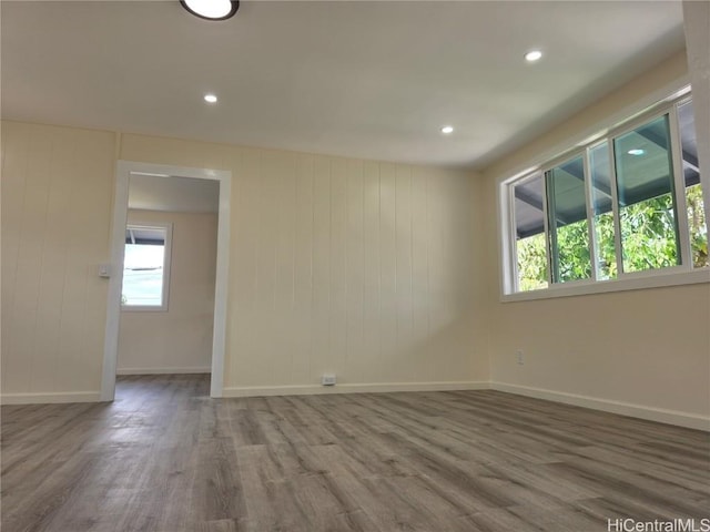 empty room featuring recessed lighting, wood finished floors, and baseboards