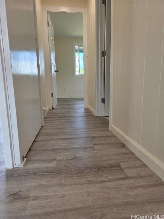 hallway featuring baseboards and wood finished floors