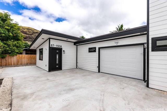 garage featuring driveway and fence