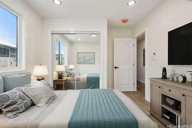 bedroom featuring baseboards, a closet, recessed lighting, and light wood-style floors