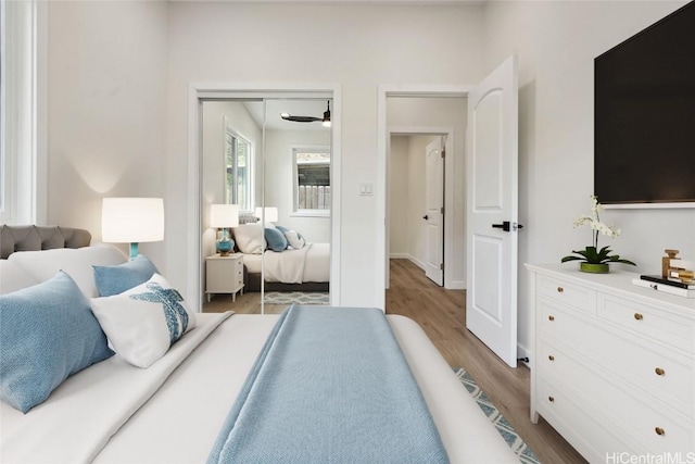 bedroom with light wood finished floors and a closet