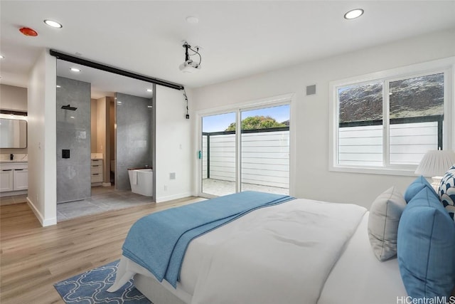 bedroom featuring light wood-style floors, recessed lighting, ensuite bath, and access to exterior