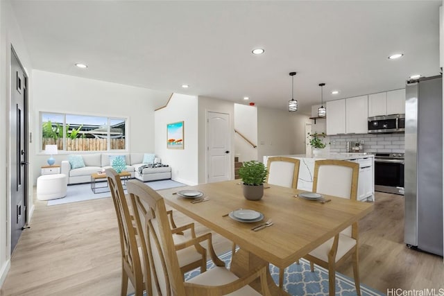 dining room featuring light wood-type flooring, stairs, and recessed lighting