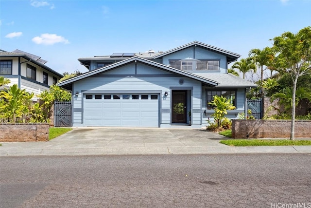 view of front of house with solar panels, concrete driveway, an attached garage, and fence