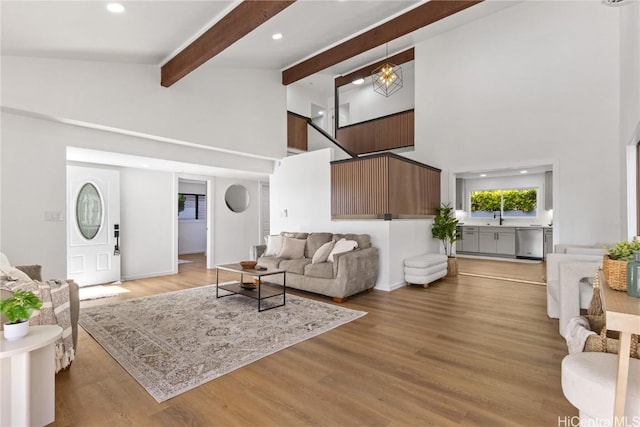 living area featuring high vaulted ceiling, light wood finished floors, beamed ceiling, and recessed lighting