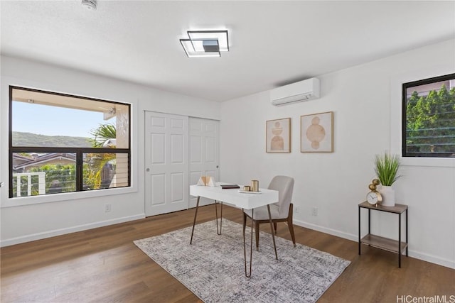 office area with a wall unit AC, baseboards, and wood finished floors