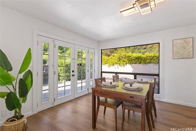 dining space featuring french doors, baseboards, and wood finished floors