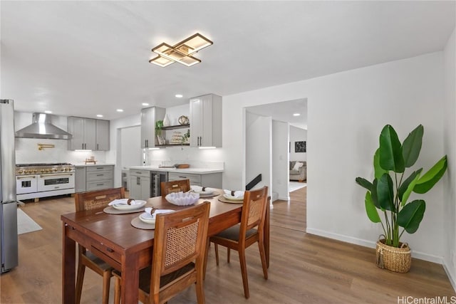 dining space featuring wine cooler, baseboards, wood finished floors, and recessed lighting