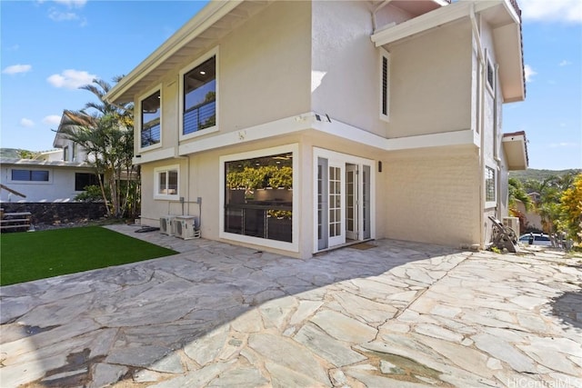 rear view of house featuring a patio area and stucco siding