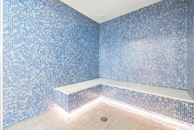 full bathroom featuring tile patterned flooring and tile walls