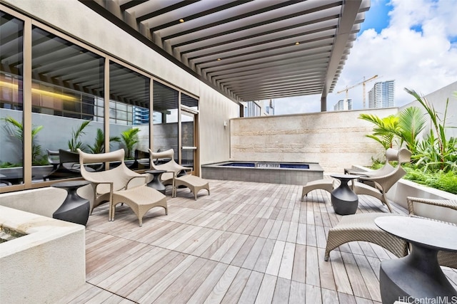 wooden terrace with a jacuzzi and a pergola