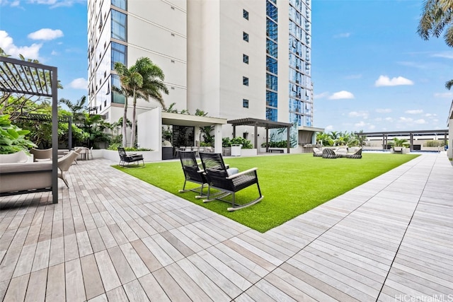 view of property's community featuring a deck, a yard, an outdoor living space, and a pergola