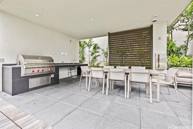 view of patio featuring outdoor dining area, an outdoor kitchen, and grilling area