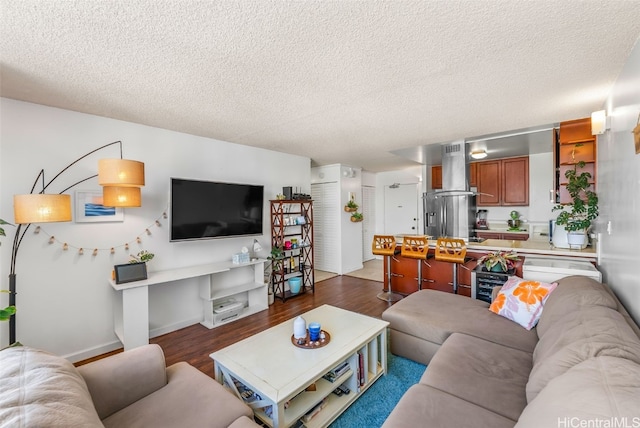 living room featuring a textured ceiling, baseboards, and dark wood-style flooring