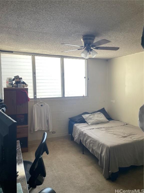 bedroom featuring carpet, a ceiling fan, and a textured ceiling