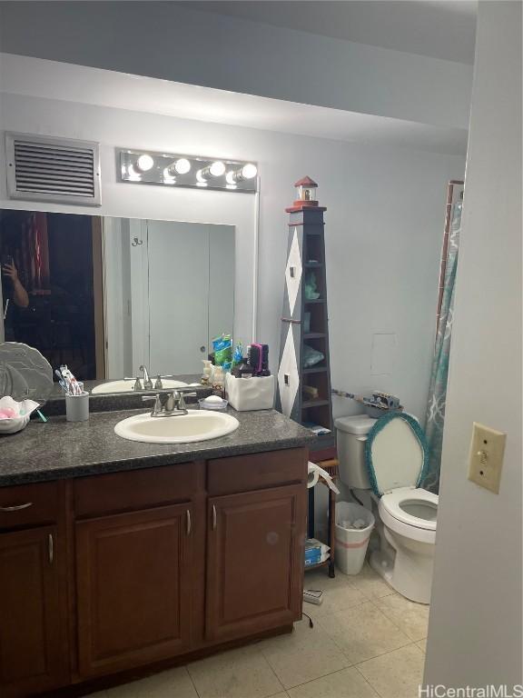 bathroom featuring toilet, vanity, and tile patterned floors