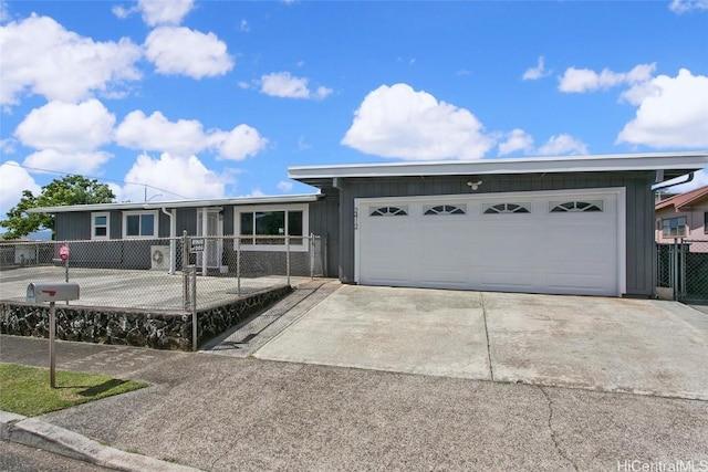 view of front of house featuring an attached garage, a fenced front yard, and concrete driveway