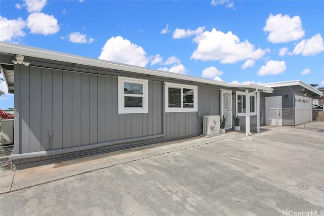 rear view of property featuring ac unit and fence