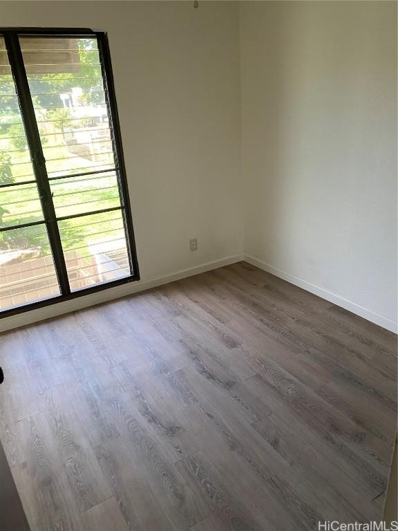 unfurnished room with baseboards and wood finished floors