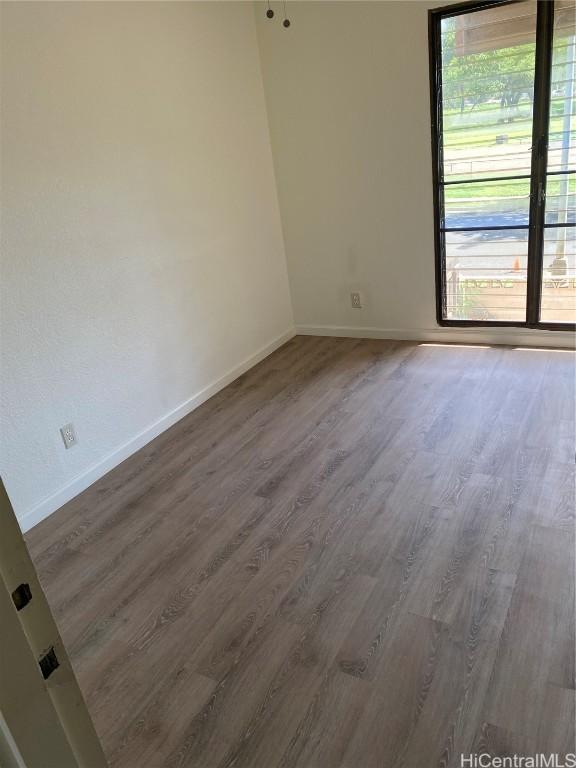 empty room with baseboards and wood finished floors