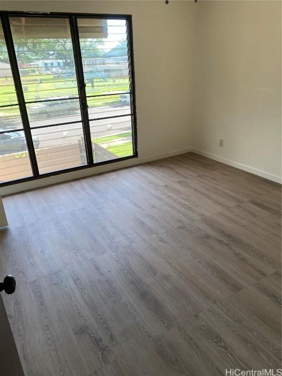 unfurnished room with wood finished floors and baseboards