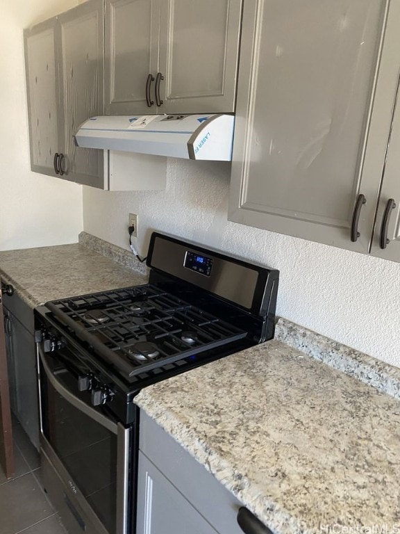 kitchen with stainless steel range with gas cooktop, extractor fan, and tile patterned floors